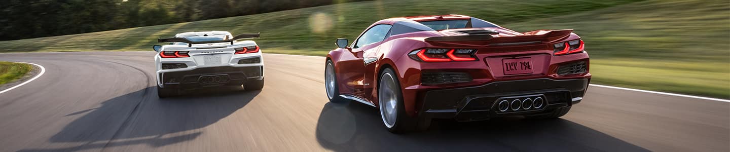 image of a maroon Corvette driving with another car in front